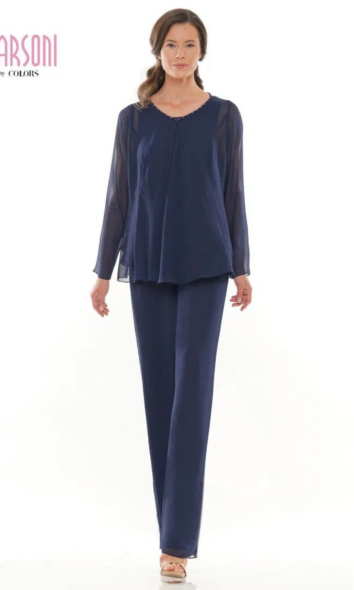 A woman wears the Marsoni M304 Long Formal Pantsuit in navy, featuring long sleeves and straight-leg pants, styled with beige open-toe shoes.